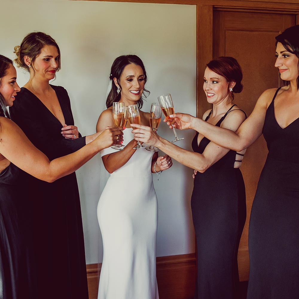 The bride and her bridesmaids toast in a 1920's craftsman home.